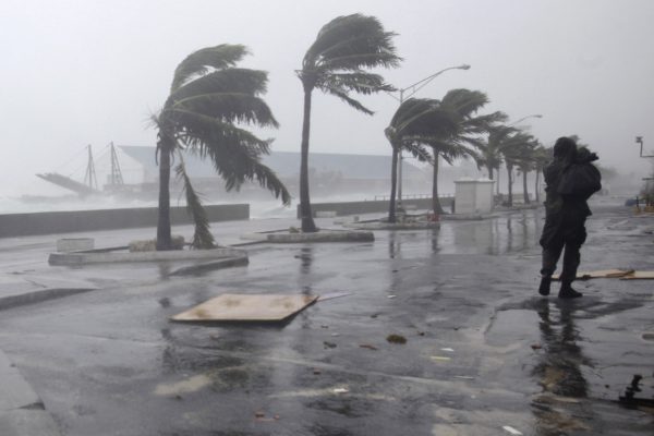 A man walks along the waterfront as Hurricane Irene passes to the east of Nassau on New Providence Island in the Bahamas, Thursday Aug. 25, 2011.  Irene is pounding the Bahamas as a Category 3 hurricane. (AP Photo/Lynne Sladky)