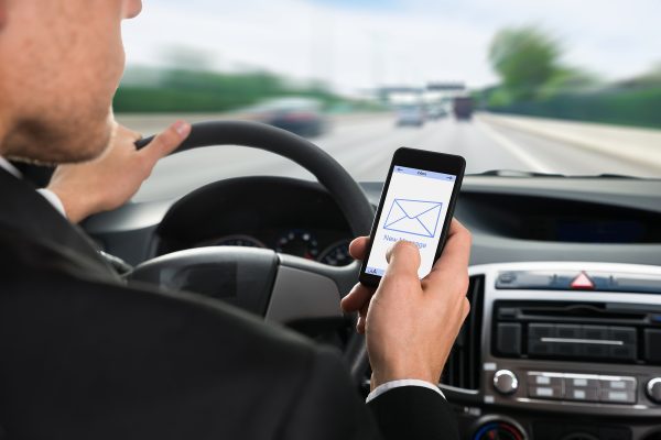 Close-up Of A Man Holding Cellphone With Message Notification While Driving Car; Shutterstock ID 286872386; PO: 0524findings