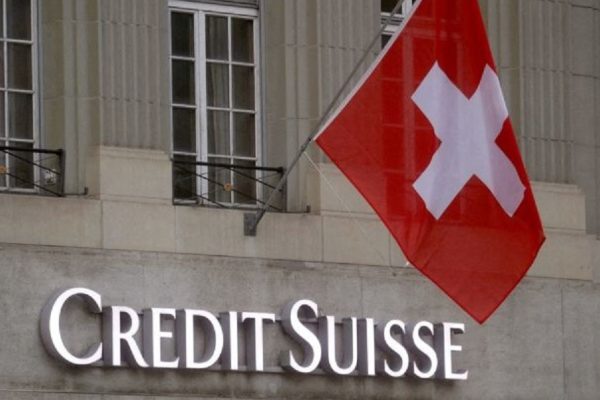 FILE PHOTO: Switzerland's national flag flies above a logo of Swiss bank Credit Suisse in front of a branch office in Bern, Switzerland November 29, 2022. REUTERS/Arnd Wiegmann/File Photo