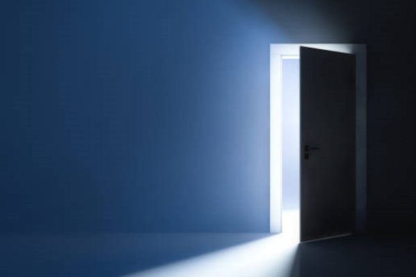Bright light behind the slightly ajar door. Abstract background