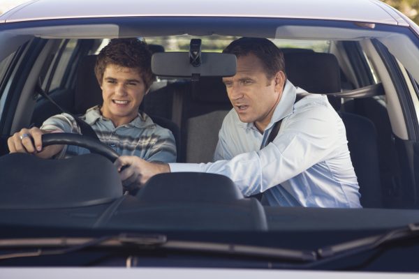 Father instructing son driving